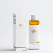 Clear bottle with gold cap and white label next to a white box with gold accents on a light gray background