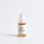 Skincare serum bottle with white cap and label on a light gray background