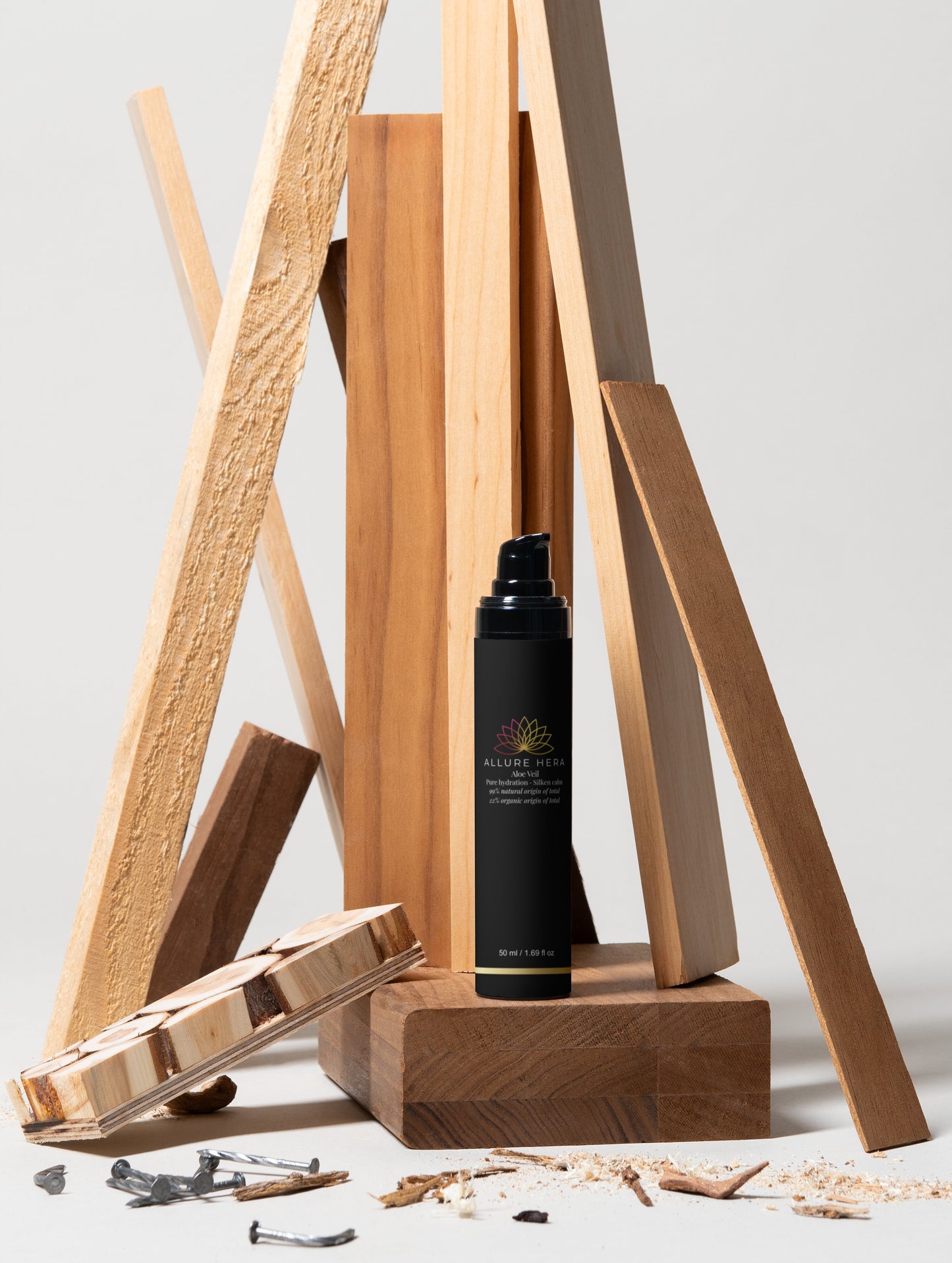 Black bottle with label on a wooden stand against a light background