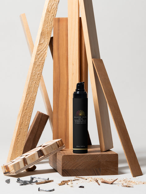 Black bottle with label on a wooden stand against a light background