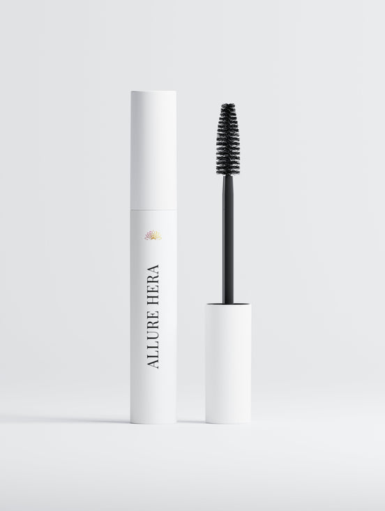 Mascara with white cylindrical container and black brush on a light gray background