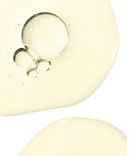 Close-up of rosemary hair and scalp strengthening oil with bubbles on a white background.